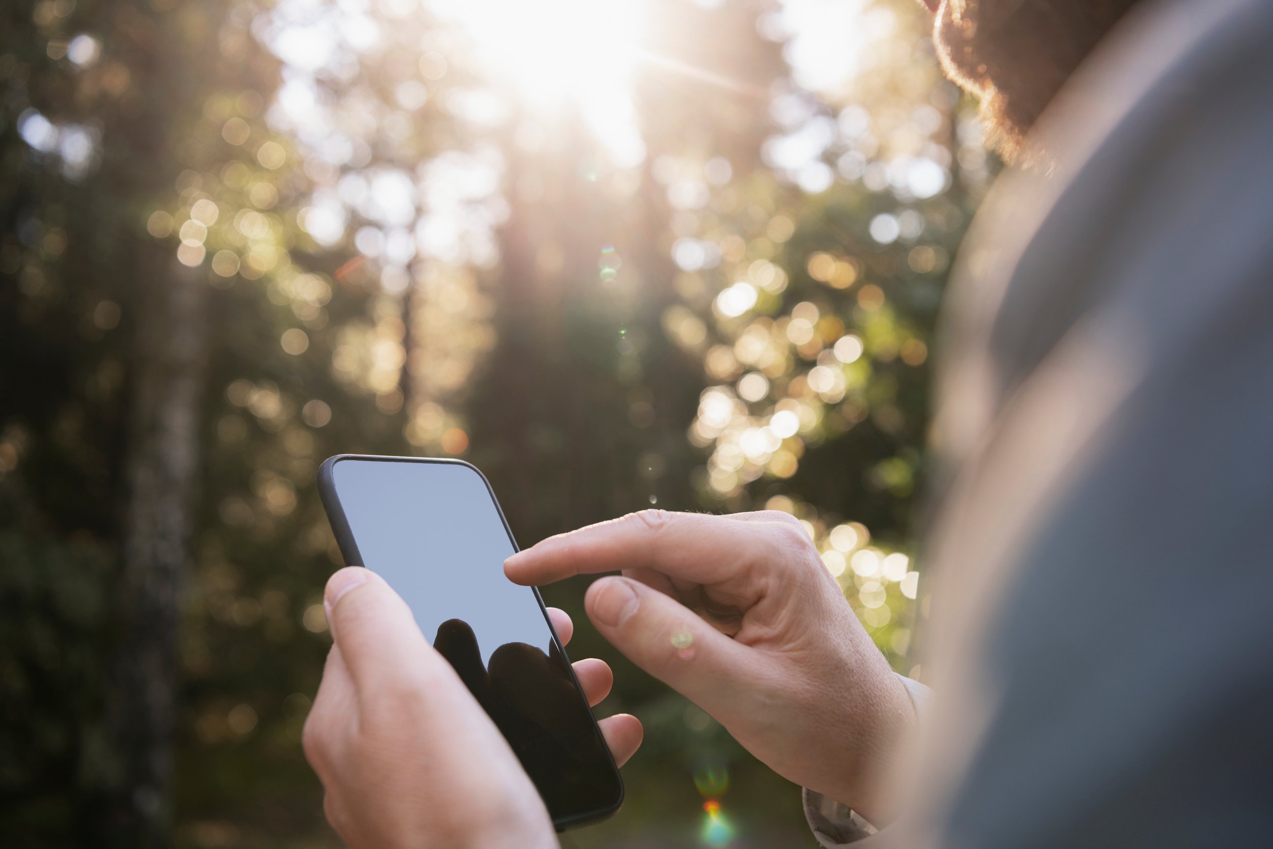 Man hands holding smartphone outdoors