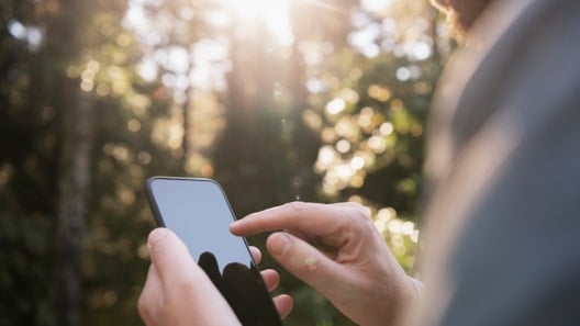 Man hands holding smartphone outdoors